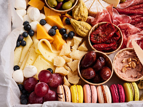 A colorful selection of cheeses, cured meats, olives, and fresh fruits arranged on a platter for an inviting dining experience. Perfect for sharing at a social gathering
