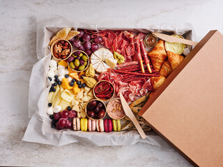 A beautifully arranged charcuterie board displays an assortment of cured meats, cheeses, fruits, nuts, and pastries. It is ideal for a casual gathering or celebration