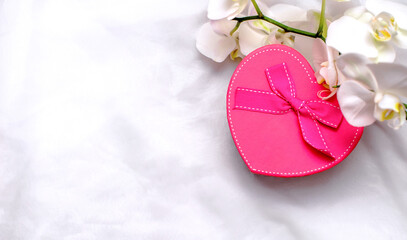 gift box in form of heart on the background of the white orchid
