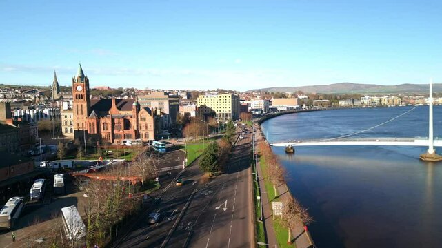 Advancing aerial shot of the Guildhall and Peace Bridge in Derry-Londonderry, NI on a bright sunny day. Filmed in 4K at 60fps and in Rec709 color space.