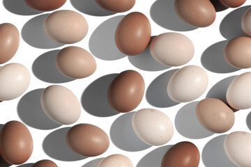 Top view Brown Eggs with shadows in white background, minimal trend food pattern from assorted natural Chicken egg with natural beige brown color eggshells, Easter food, mocha mousse trend color