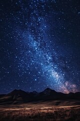 Majestic Night Sky with Milky Way Galaxy and Silhouetted Mountains over a Grassy Plain.