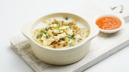 Bubur Ayam, Indonesian rice porridge served with shredded chicken and wonton crackers isolated white background