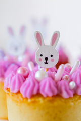 Cute Bunny Cupcake with Pink Frosting. Easter table setting.Easter baking and sweets in pastel tones.Sweet pastries for spring holidays. 