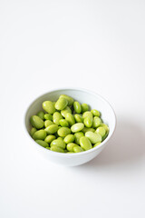 Edamame beans in white bowl
