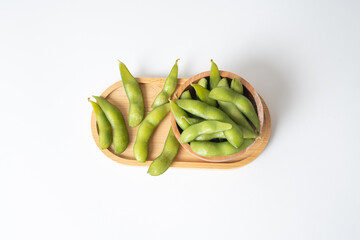 Edamame beans in wooden tray and bowl