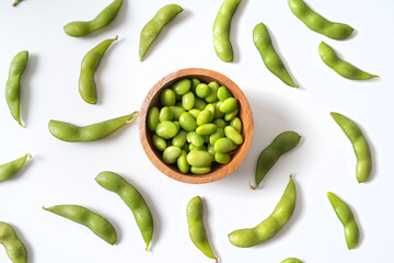 Edamame beans in wooden bowl on white background