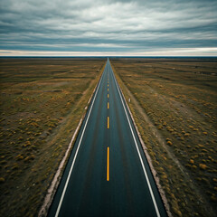 Fototapeta premium road in the countryside field. Empty road passing through grassy landscape under blue sky.