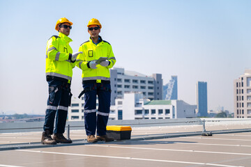 The technician Inspecting Solar Panels on a Factory Roof. An engineer wearing safety gear...