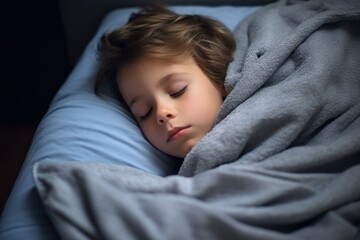 Child sleeping peacefully in bed, enjoying a restful slumber under a soft, gray blanket