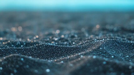 Sparkling dark sand beach texture, shallow depth of field, ocean background, website banner