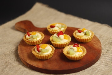 delicious fruit pie on a wooden baking sheet on a black background