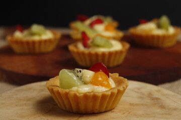 delicious fruit pie on a wooden baking sheet on a black background