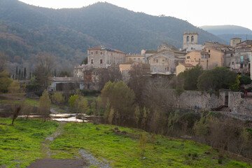 Fototapeta premium Medieval stone bridge leading to picturesque village in catalonia