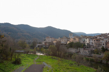 Medieval stone bridge leading to picturesque village in catalonia