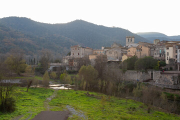 Obraz premium Medieval stone bridge leading to picturesque village in catalonia