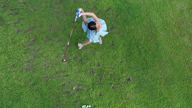 Aerial view asian girl play golf on green golf course, Woman golf player swing golf club practice, Asian girl golf player, People lifestyle