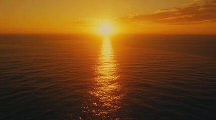 Fototapeta premium Aerial view of a serene sunset over the sea, with an orange sky, the sun setting into the ocean, and calm water reflecting the light. A tranquil and breathtaking landscape.