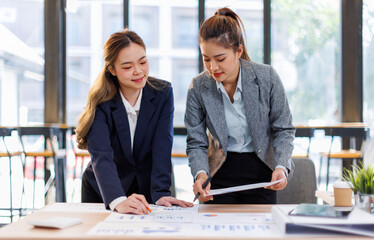 Two happy business asian women coworking with a laptop in a desktop at office.Freelance mobile office business concept.
