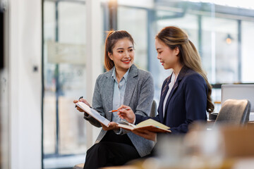 Two happy business asian women coworking with a laptop in a desktop at office.Freelance mobile...