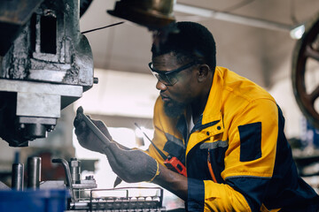 african black male worker working in heavy metal industry factory punching stamping steel machine