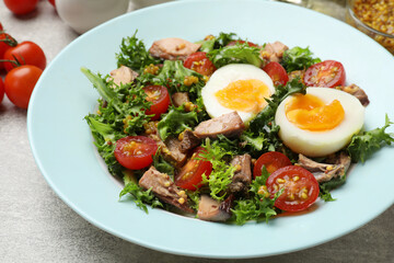 Delicious fresh tuna salad on grey textured table, closeup