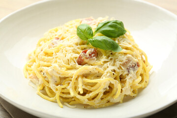 Delicious pasta Carbonara with basil in bowl, closeup