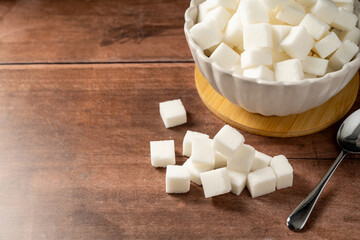White sugar cubes on wooden background. Cooking dessert ingredient
