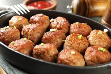 Tasty meatballs in baking dish on grey table, closeup