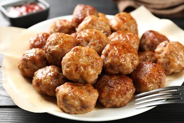 Many delicious meatballs on dark wooden table, closeup