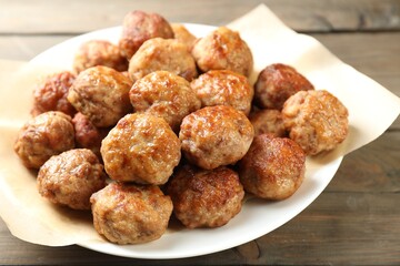 Many delicious meatballs on wooden table, closeup
