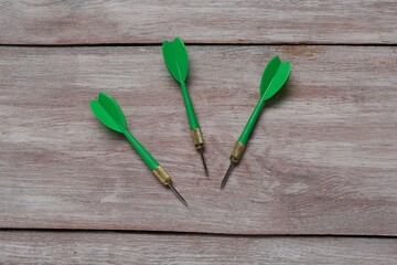 Green dart arrows on wooden rustic table, flat lay