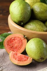 Fresh cut and whole guava fruits on table, closeup