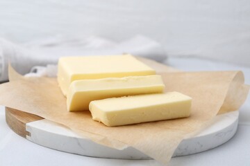 Cut block of fresh butter on white table, closeup