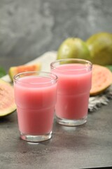 Refreshing guava juice and fresh fruits on grey table, closeup