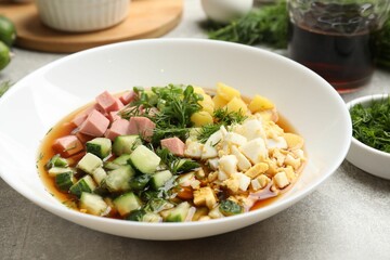 Delicious okroshka soup and ingredients on grey table, closeup