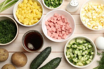 Different ingredients for okroshka soup on white wooden table, flat lay