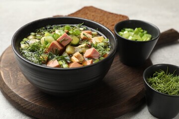 Delicious okroshka soup with kvass and ingredients on light table, closeup