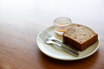 Moist Peanut butter Banana bread sliced with sauce on ceramic plate on wooden background.