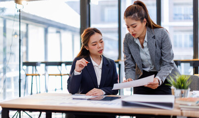 Financial Business two women analyze the graph of the company's performance to create profits and growth, Market research reports and income statistics, Financial and Accounting concept.	

