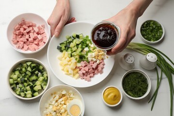 Making okroshka soup. Woman with bowl and different ingredients at white marble table, top view