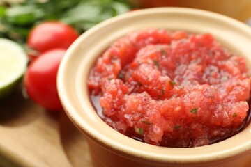 Spicy salsa sauce in bowl on table, closeup