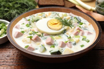 Delicious okroshka soup with kefir served on wooden table, closeup