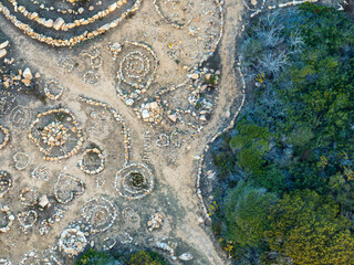 Aerial view of human made stone circle patterns of land art in coastal area in Sardinia.