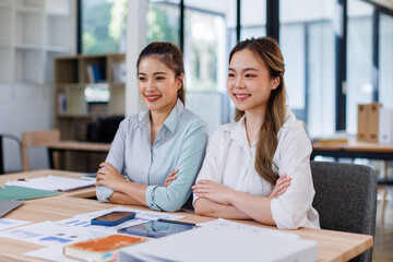 Entrepreneur Happy Asian business two women discussing new business project in tablet in modern Meeting In Modern Office, Asian business casual concept.
