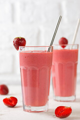 Pink strawberry smoothie with coconut cream and green buckwheat on white background. Lactose and sugar free. Vertical orientation.