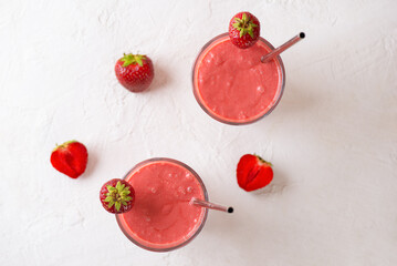 Strawberry smoothie with coconut cream on white table. Lactose and sugar free. Vertical orientation, top view.