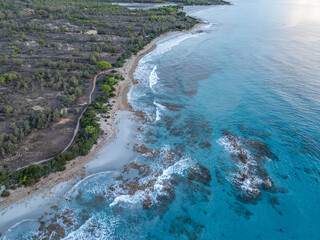 Aerial view of coast in Sardinia, Italy. Beach along coastline in Mediterranean Sea with waves and turquoise water.