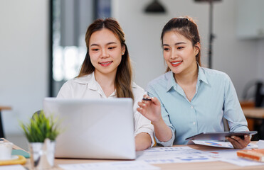 Asian Business women using calculator and laptop for doing math finance on an office desk, tax,...