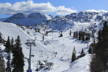 People having ski time in ski resort on a cold winter sunny day.